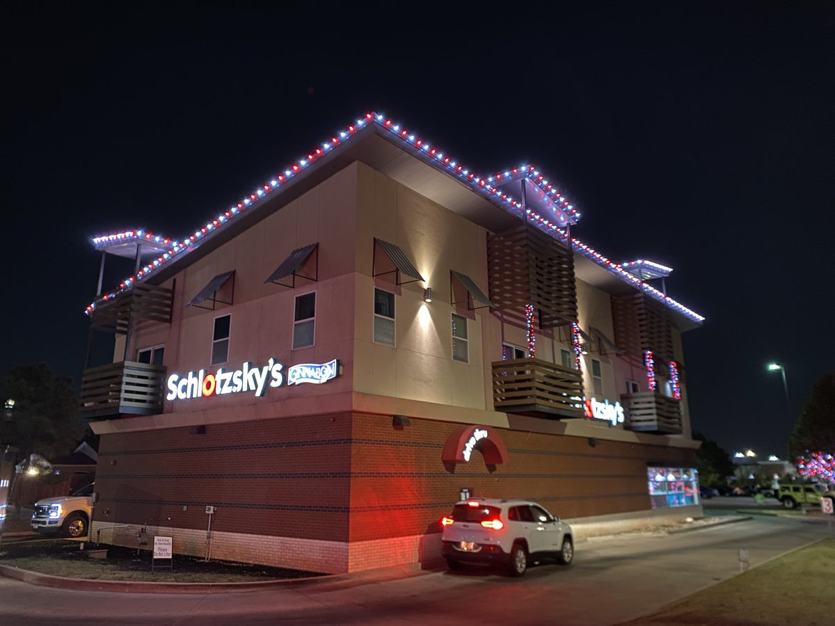 Commercial building with red white and blue roofline lights and lit railings