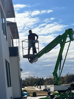 Installer working from a boom lift on a roofline during the day