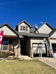 Crew working on a roof installing Christmas lights on a clear day